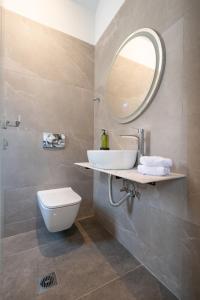 a bathroom with a sink and a toilet and a mirror at Aithra Lemnos in Thános