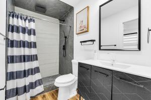 a bathroom with a toilet and a sink and a shower at Modern Home with large private yard - Next to downtown & beach & airport - Pet friendly in Fort Lauderdale +20 photos