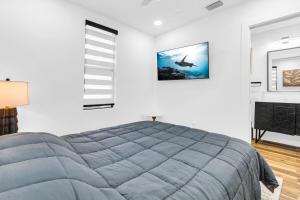a bedroom with a large bed in a white wall at Modern Home with large private yard - Next to downtown & beach & airport - Pet friendly in Fort Lauderdale