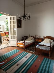 a living room with two beds and a chandelier at Casa rosa 2 in Mercedes