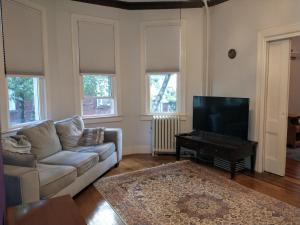 a living room with a couch and a flat screen tv at 2 Bedroom Unit and Big Yard 30 Minutes to NY in Ridgefield Park