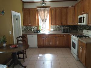 a kitchen with wooden cabinets and a table and a window at 2 Bedroom Unit and Big Yard 30 Minutes to NY in Ridgefield Park