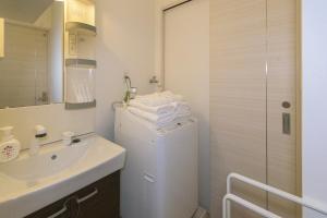 Un baño blanco con lavabo y lavadora. en Elisabeth Hakata, en Fukuoka
