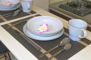 un tazón con una flor en una mesa con cucharas en Elisabeth Hakata, en Fukuoka