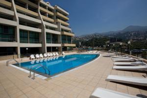 a swimming pool with lounge chairs and a building at Adma Blue Screen in Jounieh