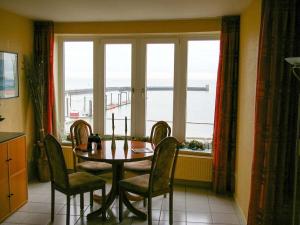 Un comedor con mesa y sillas y una ventana. en 1-bedroom apartment, en Cuxhaven 12 fotos más