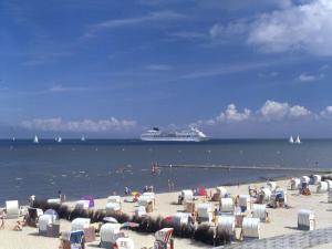 una playa con sillas y un crucero en el agua en 1-bedroom apartment, en Cuxhaven