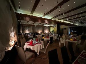a dining room with white tables and chairs at Schwanen-Resort in Baiersbronn