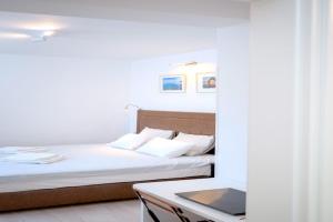 ein Schlafzimmer mit einem Bett und einem Tisch mit einem Laptop in der Unterkunft Nicely decorated house with top roofed terrace in Vrboska