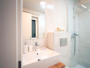 ein weißes Badezimmer mit Waschbecken und Dusche in der Unterkunft Nicely decorated house with top roofed terrace in Vrboska + 25 Fotos