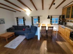 Una sala de estar con un sofá azul y una mesa. en Grand Reverend Deichstern, en Großwürden
