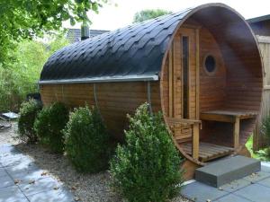 Casa amplia de madera con porche y banco en Grand Reverend Deichstern, en Großwürden
