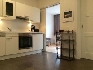 a kitchen with white cabinets and a shelf in it at Holiday apartment with 2 bedrooms in Cuxhaven