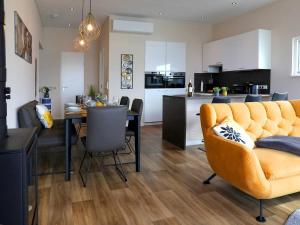 a living room and kitchen with a table and a yellow couch at Coastal Comfort with Terrace in Ribnitz-Damgarten