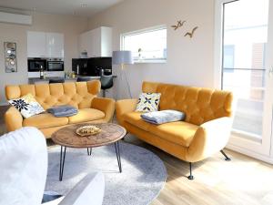 a living room with two couches and a table at Coastal Comfort with Terrace in Ribnitz-Damgarten +32 photos
