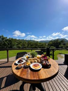 a wooden table with food on top of a deck at Chale Bouganville Ituporanga JACUZZI in Ituporanga