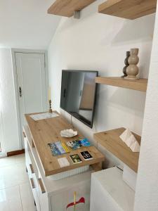 cocina con escritorio de madera y TV. en Apartamento Aqua Marina, en O Grove