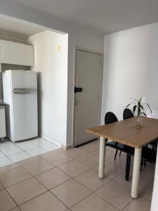 a kitchen with a wooden table and a refrigerator at Apartamento Toscana in Franca +6 photos