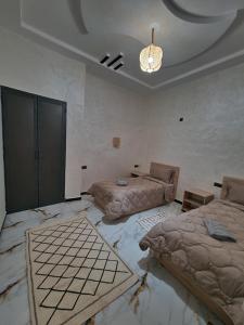 Zimmer mit 2 Betten und einem Kronleuchter in der Unterkunft Appartement In Ksar Ait Ben Haddou in Aït-Ben-Haddou + 17 Fotos