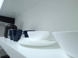 a counter with white plates and bowls on it at Boracay Luxury Apartments in Boracay