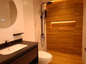 a bathroom with a toilet and a sink and a shower at Boracay Luxury Apartments in Boracay
