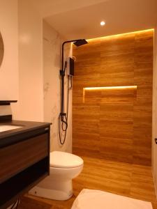 a bathroom with a shower with a toilet and a sink at Boracay Luxury Apartments in Boracay