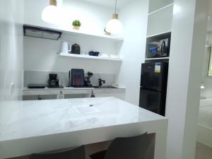 a kitchen with a white counter and a black refrigerator at Boracay Luxury Apartments in Boracay