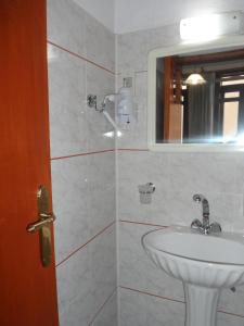 a white bathroom with a sink and a mirror at Anemones Rooms in Chania +65 photos