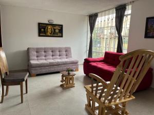 a living room with a couch and a chair at Casa de Huéspedes Pontevedra - cerca a la clínica Shaio, Pontevedra in Bogotá