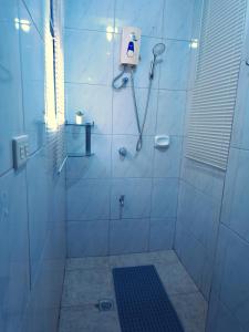 a white bathroom with a shower with a shower head at Boracay Luxury Apartments in Boracay