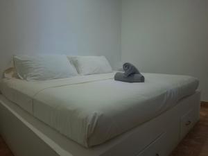 a white bed with a stuffed animal sitting on it at Boracay Luxury Apartments in Boracay