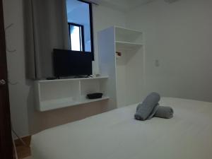 a white room with a bed with a tv on it at Boracay Luxury Apartments in Boracay