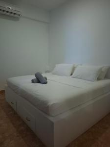 a white bed with two pillows on top of it at Boracay Luxury Apartments in Boracay