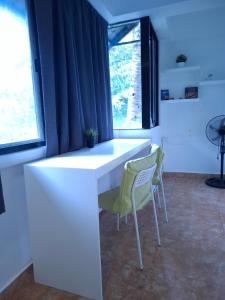 a white desk and two chairs in a room with windows at Boracay Luxury Apartments in Boracay