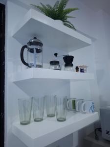 a shelf with four empty glasses on it at Boracay Luxury Apartments in Boracay