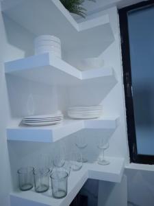a white shelf with plates and glasses on it at Boracay Luxury Apartments in Boracay