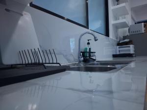 a kitchen counter with a sink and a mirror at Boracay Luxury Apartments in Boracay