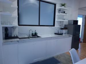 a kitchen with a sink and a black refrigerator at Boracay Luxury Apartments in Boracay