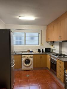 une cuisine avec une machine à laver et une fenêtre dans l'établissement Ria apartments, à Aveiro