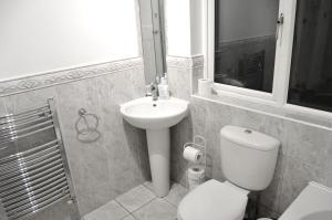 a bathroom with a white toilet and a sink at East Croydon in South Norwood