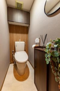 a bathroom with a toilet and a wooden wall at Premier suite Shinjuku okubo Tokyo 3F in Tokyo