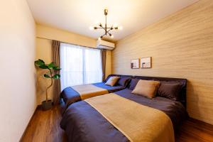 a bedroom with two beds and a window at Premier suite Shinjuku okubo Tokyo 3F in Tokyo