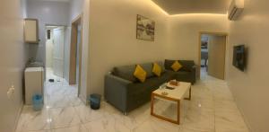 a living room with a green couch and a table at Sukoon alraha serviced apartment in Hafr Al-Batin +28 photos