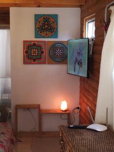a room with a desk with a laptop and pictures on the wall at Ananda Ganesha in Villa Ventana