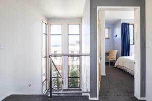 a bedroom with a bed and a balcony at Spacious modern executive home in Wellington