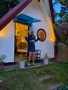 a woman standing in front of a house holding a tennis racket at Stargate Villa in Talalla