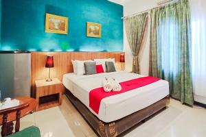 een slaapkamer met een groot bed met schoenen erop bij RedDoorz near Focal Point Medan in Sunggal