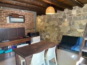 a dining room with a wooden table and chairs at Cabañas Cuyum in El Volcán