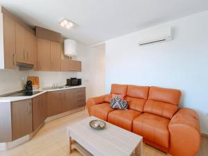 salon z pomarańczową kanapą i kuchnią w obiekcie Cala Chica Suites 2 hab con vistas al mar y terraza w mieście El Cabo de Gata