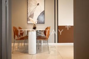 a dining room with a white table and chairs at Bay Suites by Pinstay Plus in Kota Kinabalu